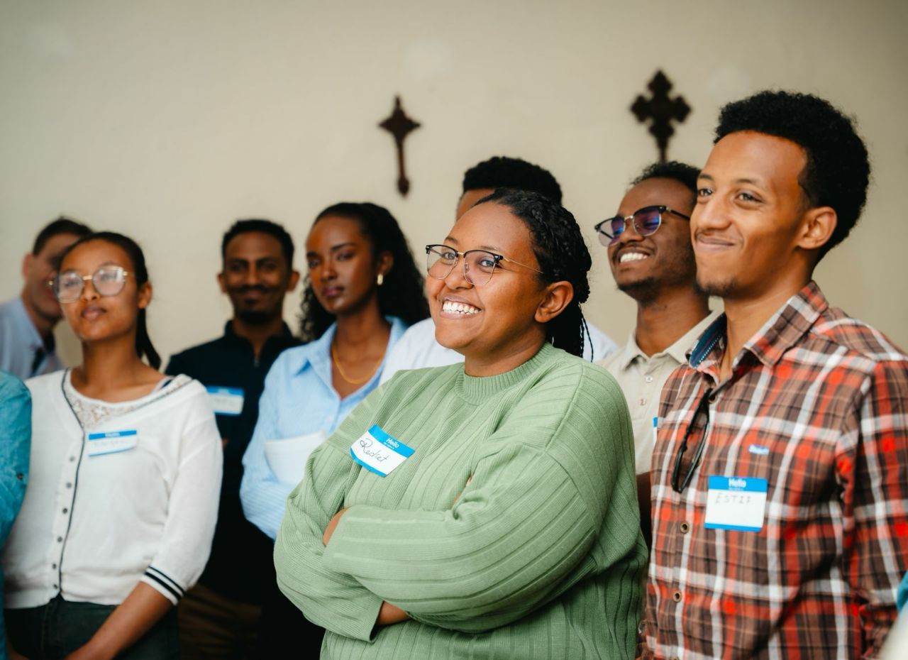 A group of smiling young men and women wearing name tags